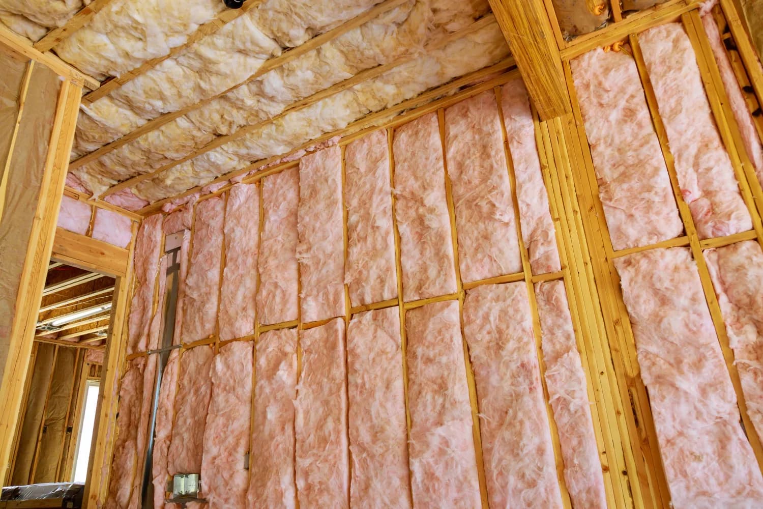 Pink fibreglass batt insulation installed in wall framing